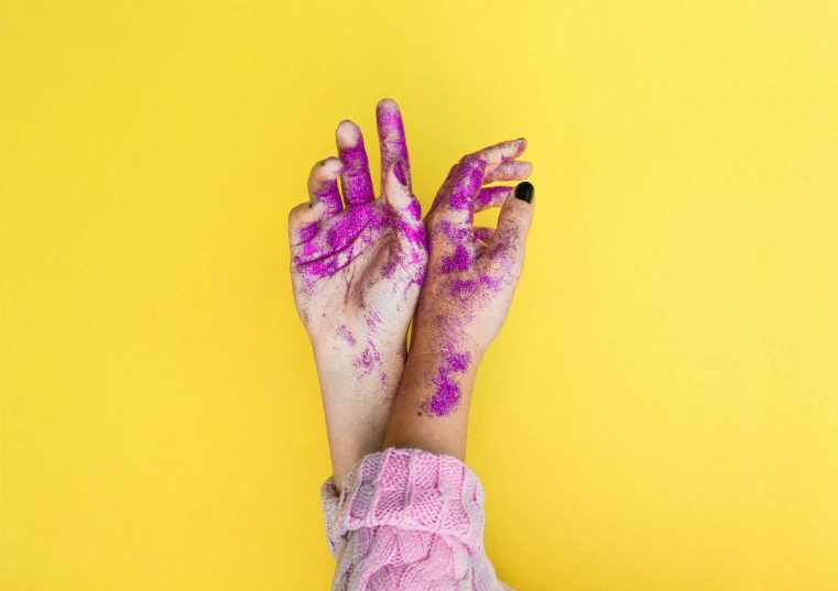 someones hands with pink powder all over them and fingers