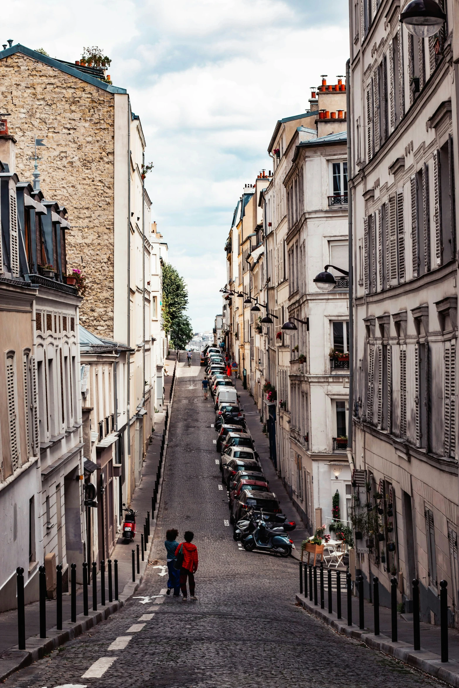 a narrow and empty street with parked cars