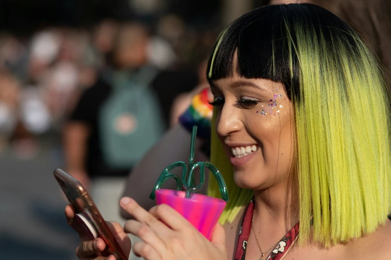 a woman with green hair, holding a pink phone