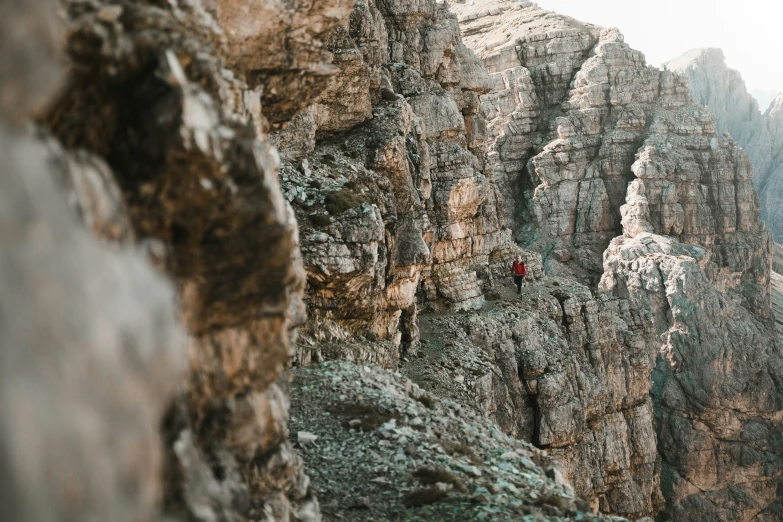 a man walking up the side of a cliff