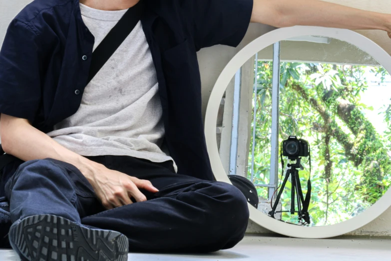 a man sitting on the ground while holding a phone