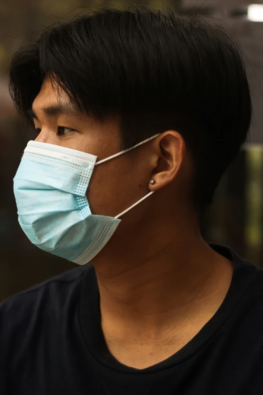 a man with an ear tube and a blue face mask