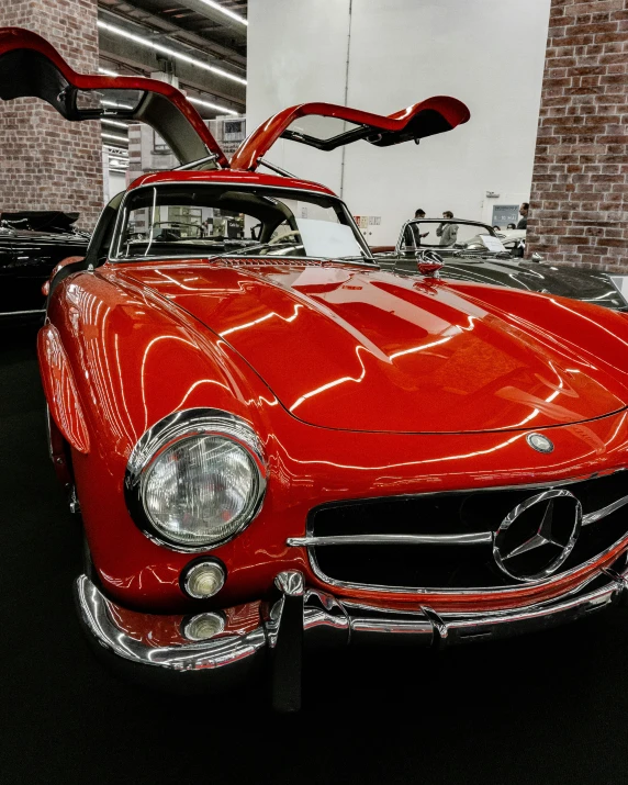 two red classic cars parked in a garage