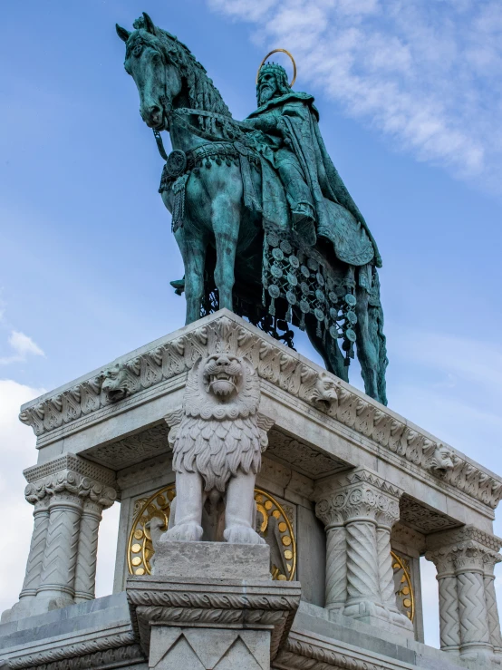 a tall horse and rider statue in the middle of a field