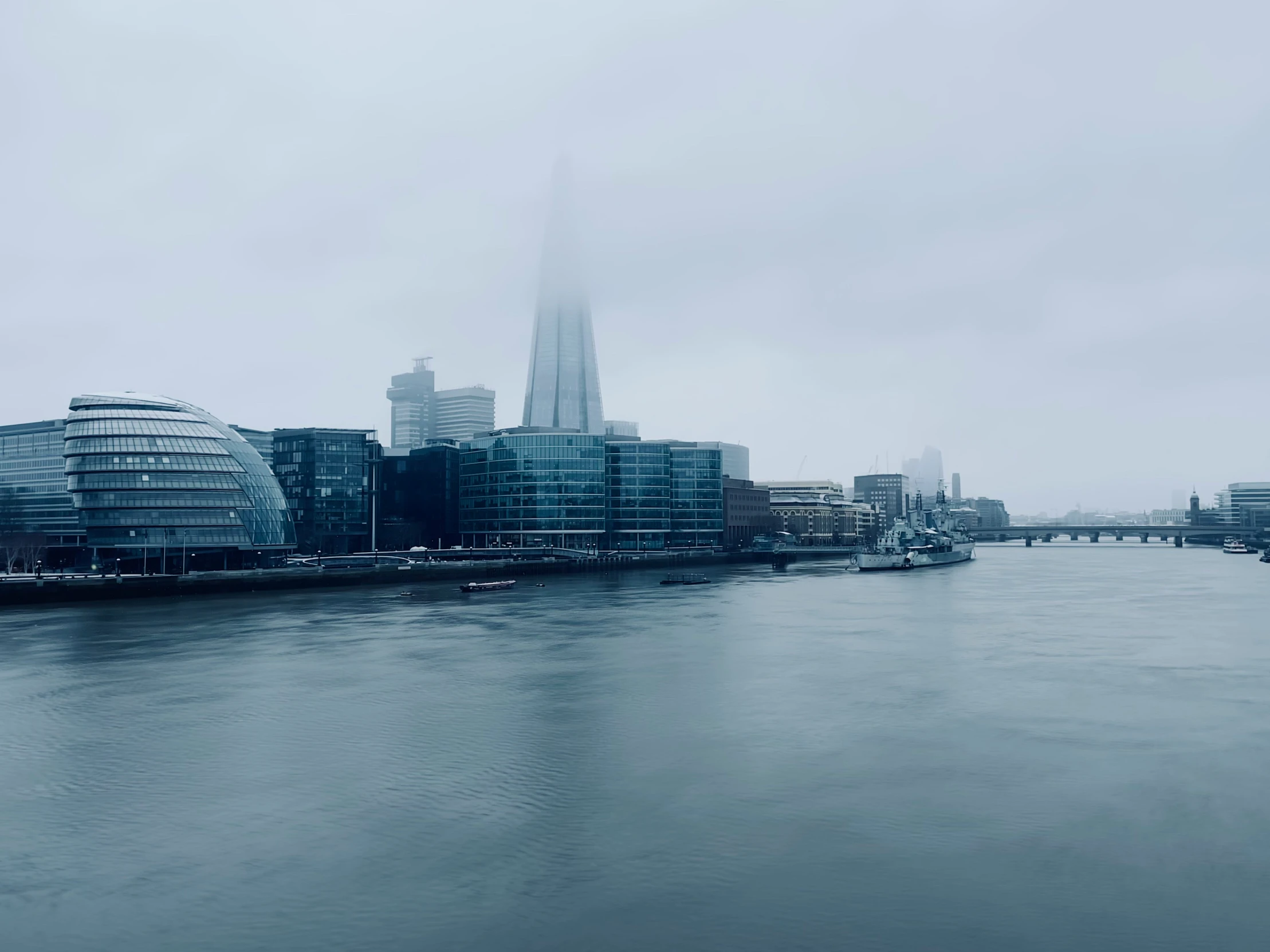 an image of some buildings along the river in the fog