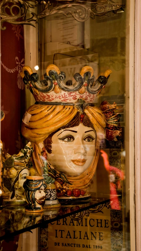 a mannequin wearing a crown and ornate clothing in a window