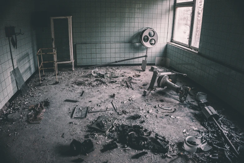 a large room with a ladder, broken toilet and various objects on the floor