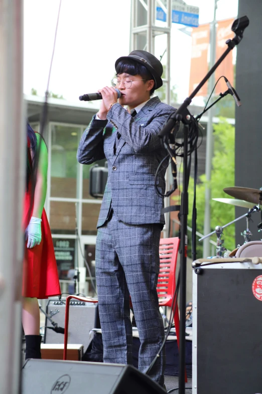 a man in a suit sings into a microphone