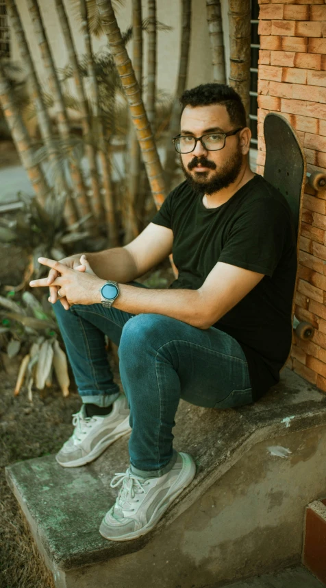 a man sitting on a bench with his skateboard