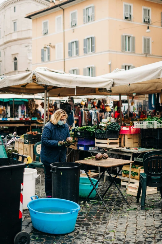 a woman standing on the sidewalk next to tables