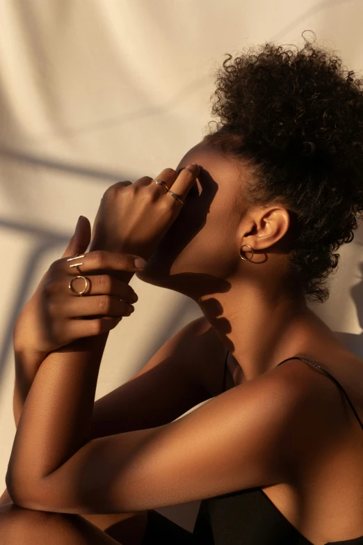 a woman with black hair wearing gold rings