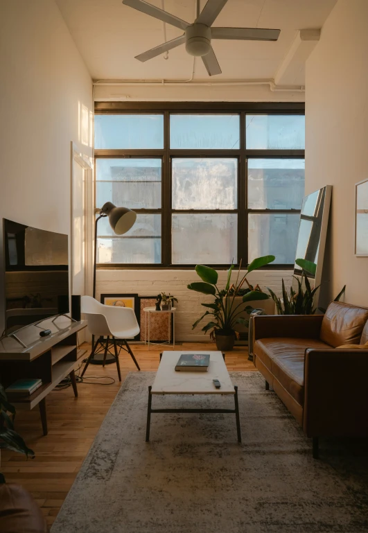 a living room with large windows next to a wall