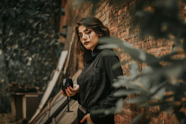 a woman standing in front of a brick wall while holding a phone