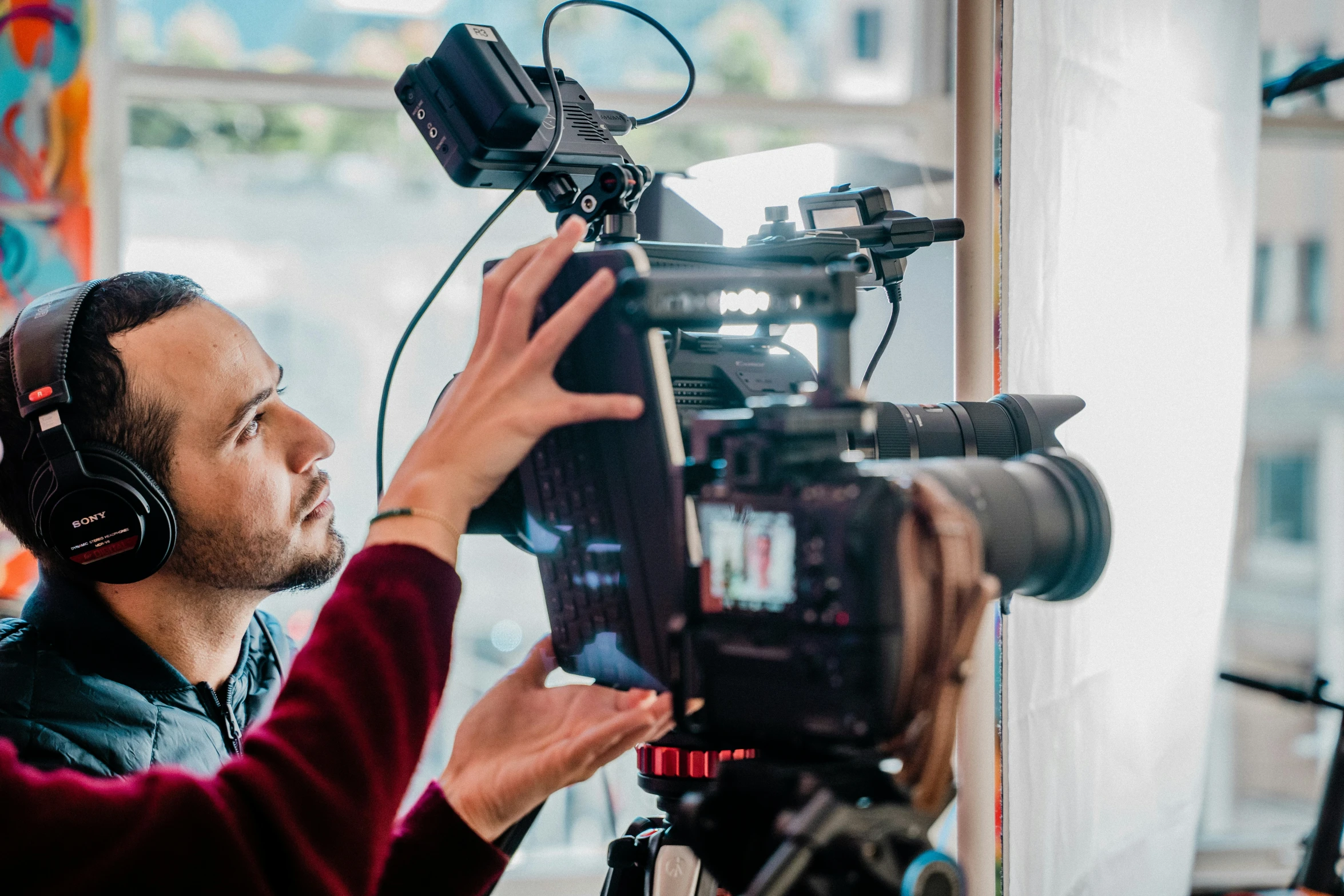 a man holding onto a camera on a tripod