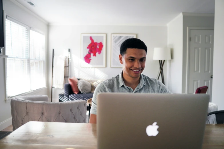 man sitting in front of an apple laptop computer