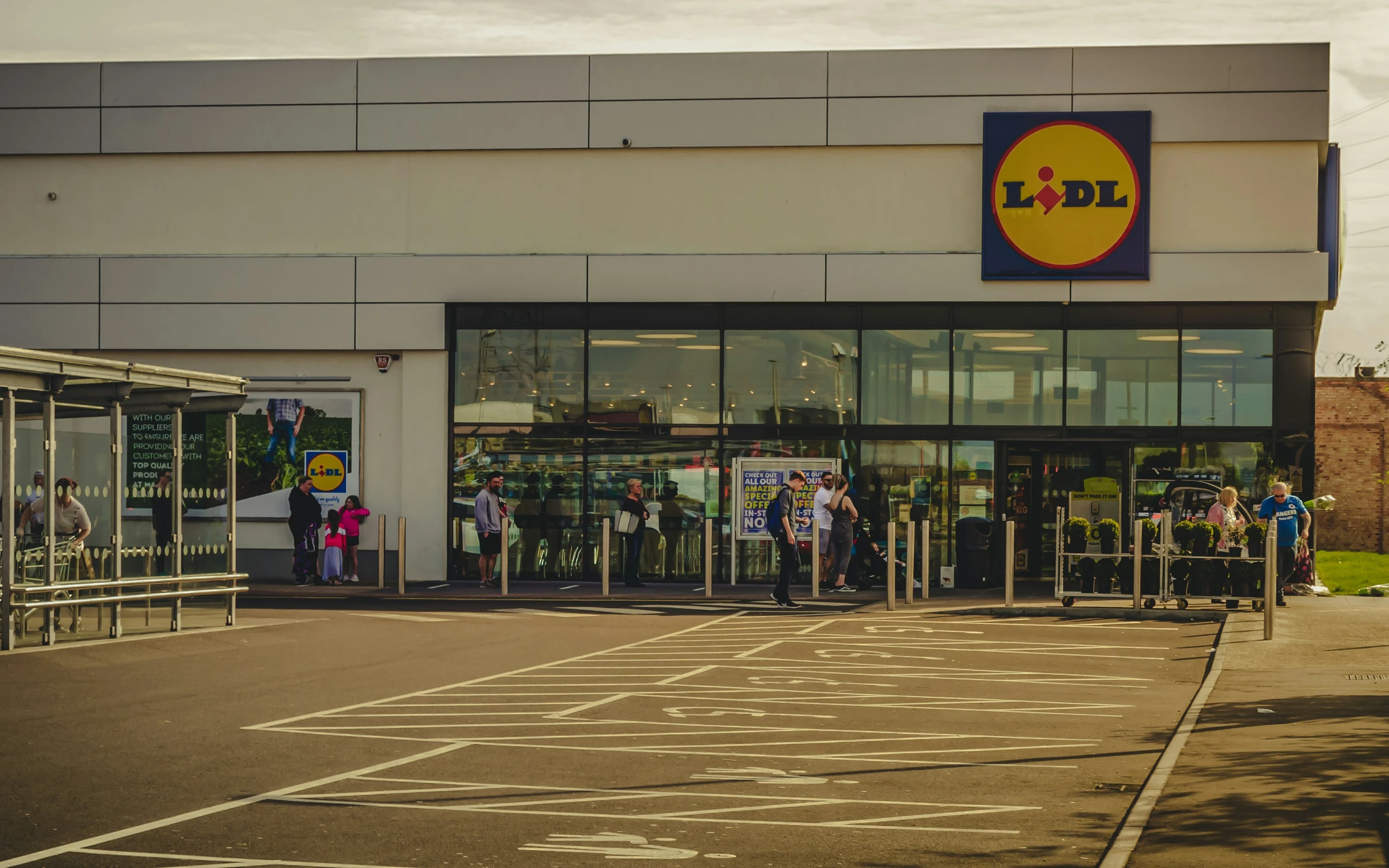 shoppers are lined up outside of the front of a store