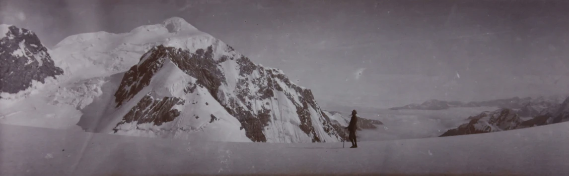 the lone person stands on the snow covered mountain