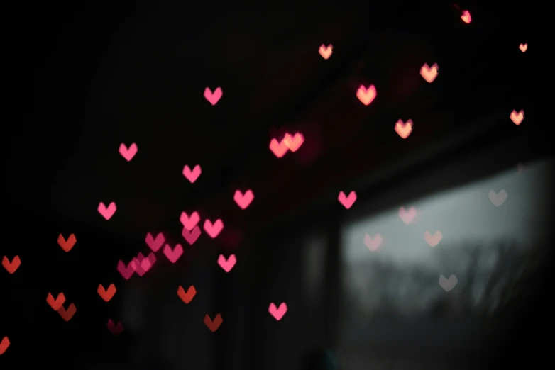 many hearts hanging from a ceiling that are covered in pink hearts