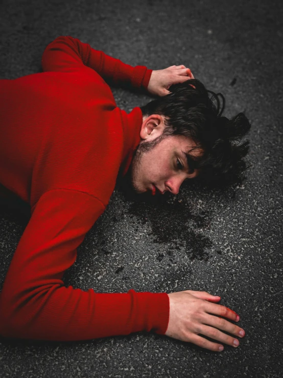 a man lying on the ground with his hand on his head