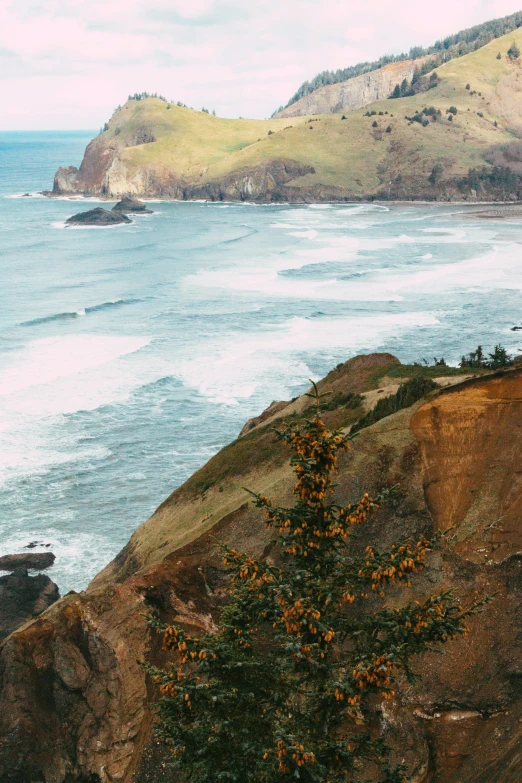 an open area with blue water, a hill, a lighthouse, and other land on one side