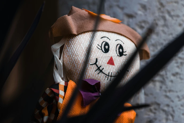 a stuffed doll wearing an orange and white striped top