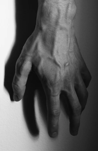 a person's hand that is casting a shadow on a wall