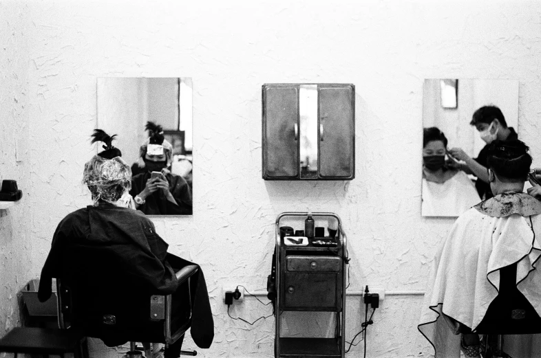 black and white image of a barber getting ready to cut a woman's hair