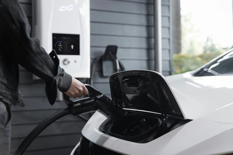 the man is using his electric car at the gas station