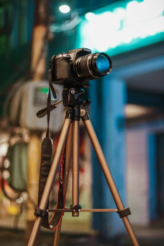 camera on tripod next to a street at night