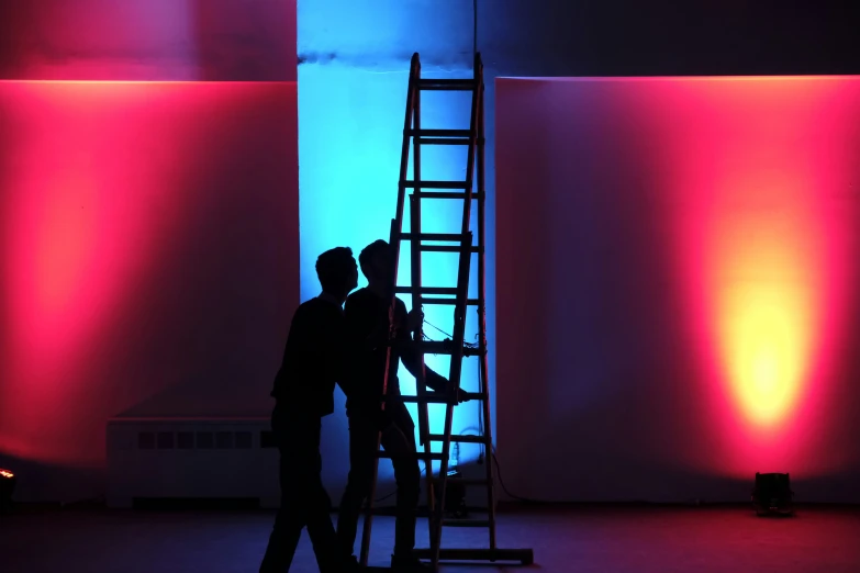 a couple of people are standing on a ladder