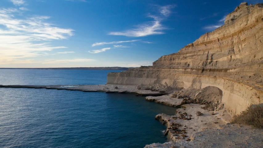 a view of the water next to a rocky cliff face