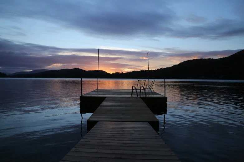 a boat dock in a lake at sunset