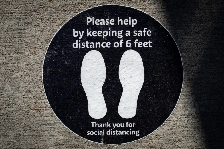 a black round sign stating the distance of feet on the ground