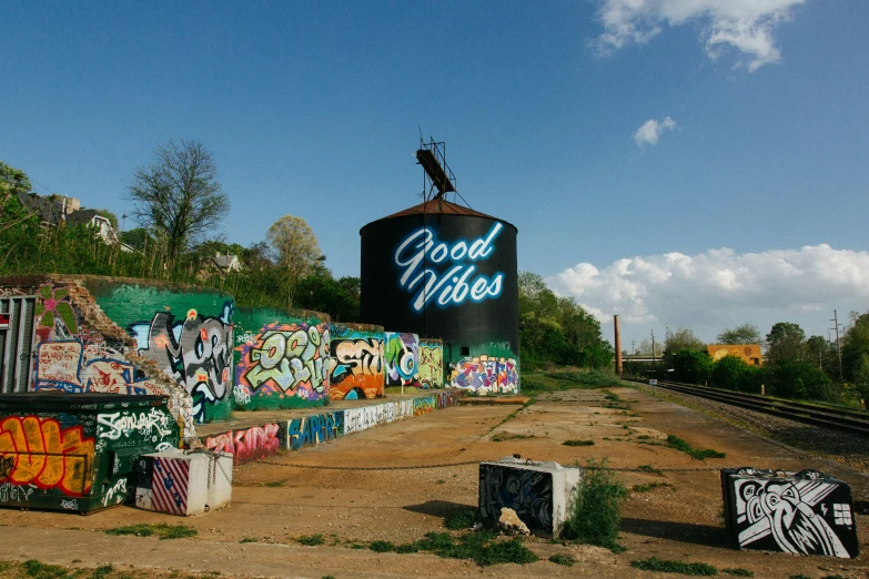 graffiti painted on a fence and cement near train tracks