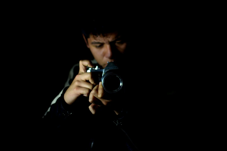 a man taking a picture with a cellphone in the dark