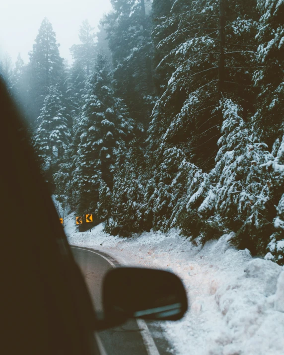 a view of the snowy ground through a car's window