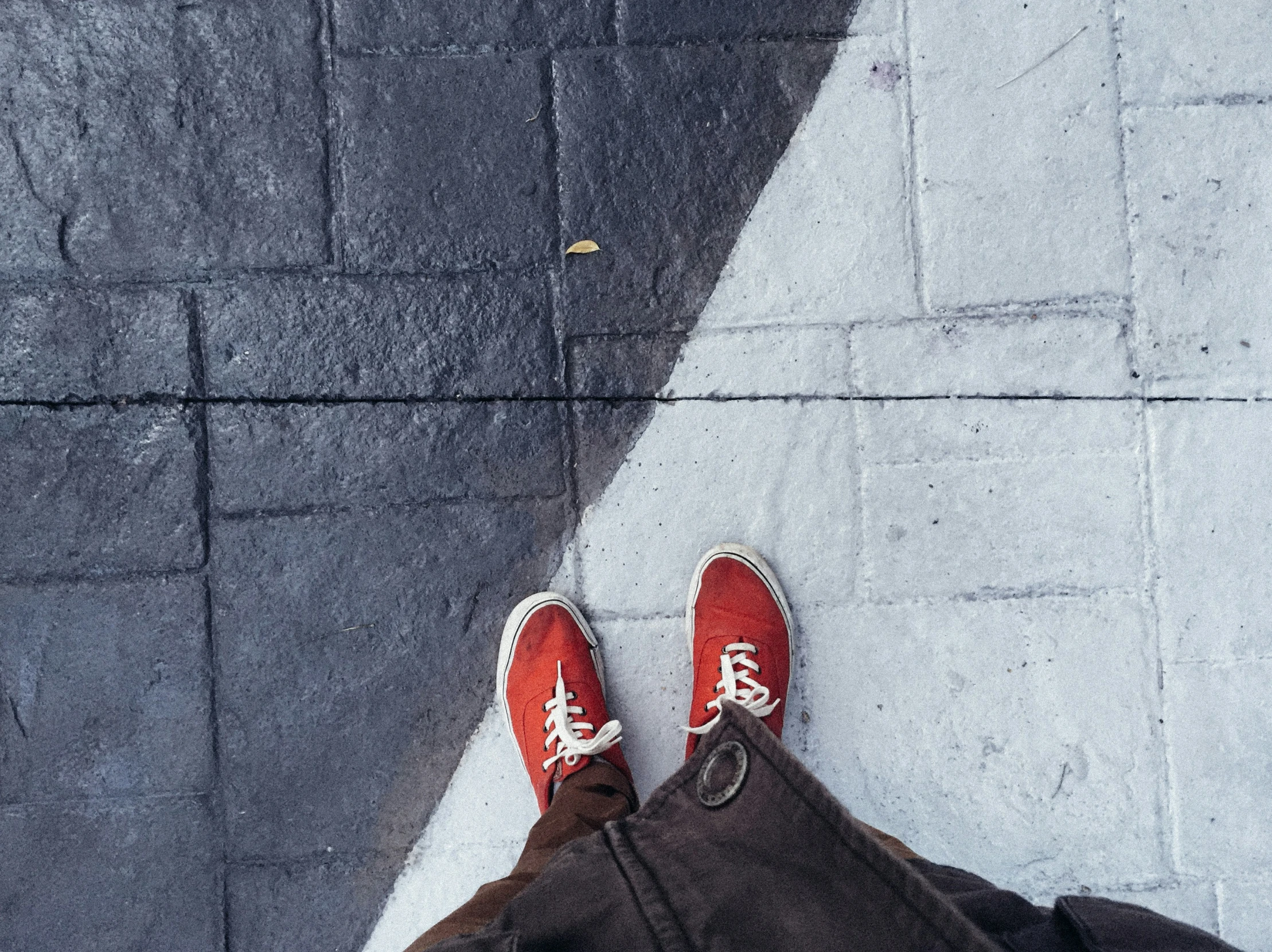 someone wearing red shoes and looking at the street