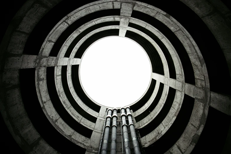 a circular concrete structure with pipes and arches