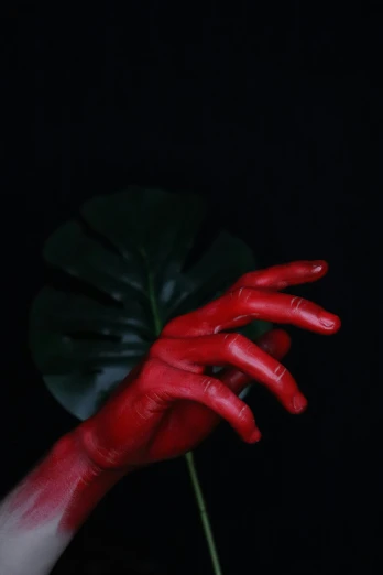 a plant with red hands coming out of it