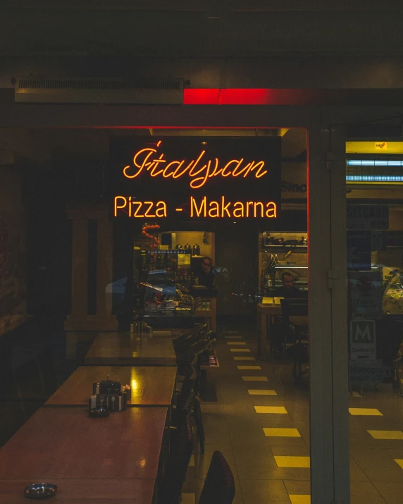 a restaurant sign above a long table with two glasses