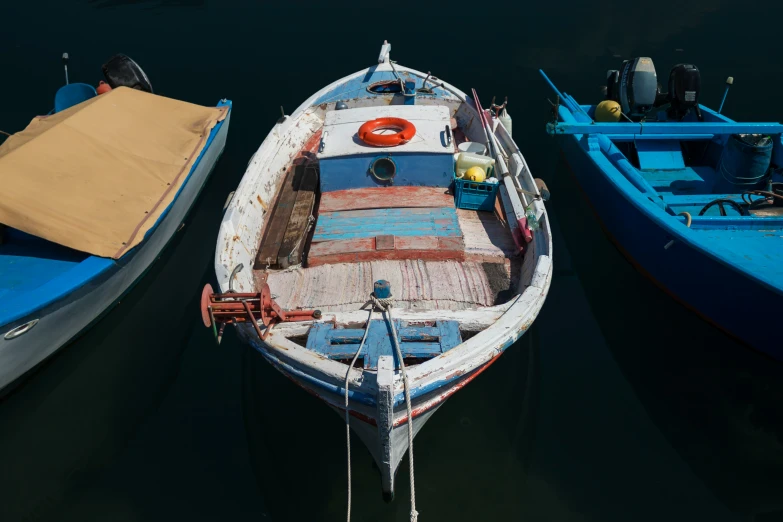 three boats are sitting in the water near one another