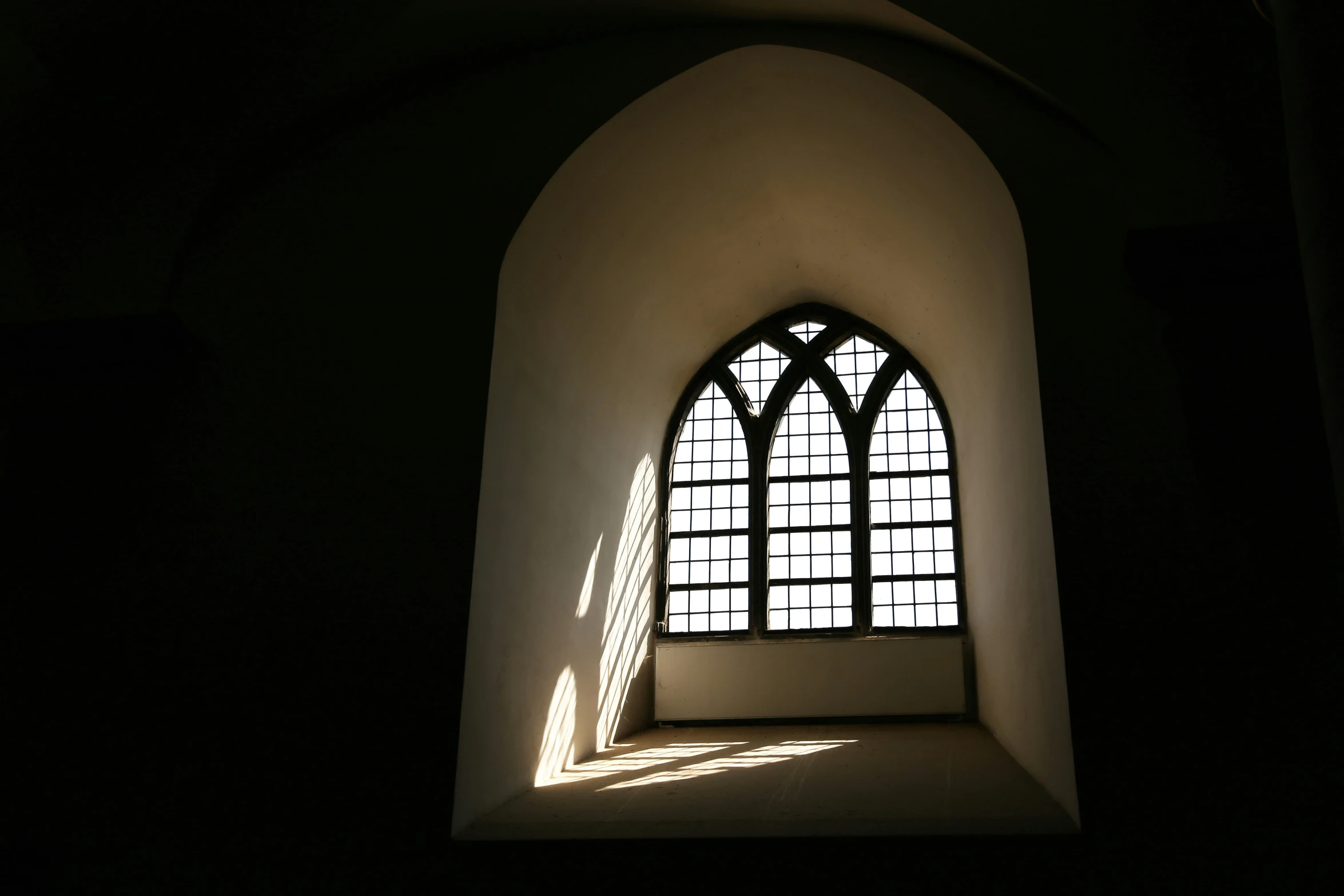 the sunlight streams through an arch and casts a shadow on it