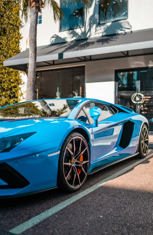 a blue sports car is parked near a building