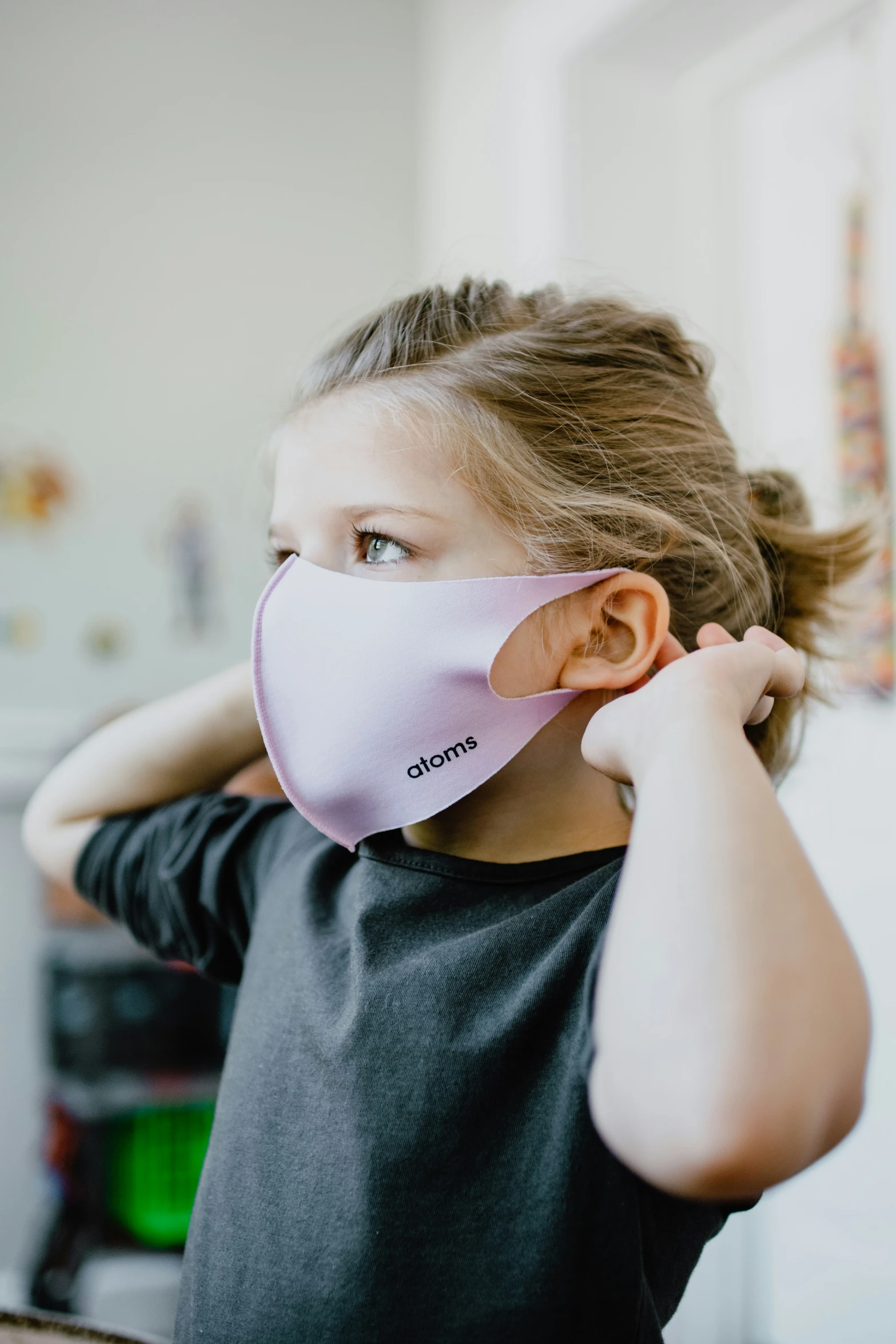 a girl in black and white is covering her face with a pink mask