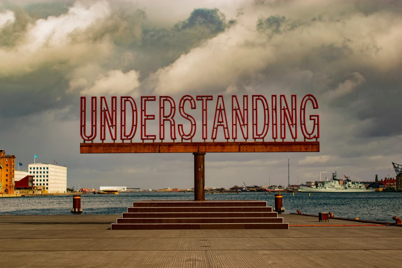 the sign that reads, understanding with a cloudy background