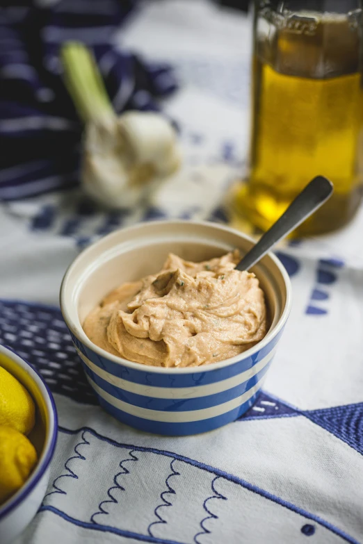 a bowl of dip sits on a table with bananas