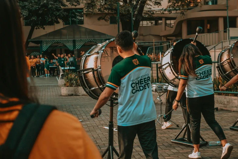a band plays drums near the road in front of people