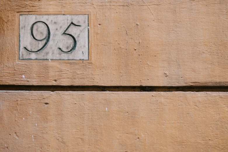 a door number plate is displayed on a wooden door