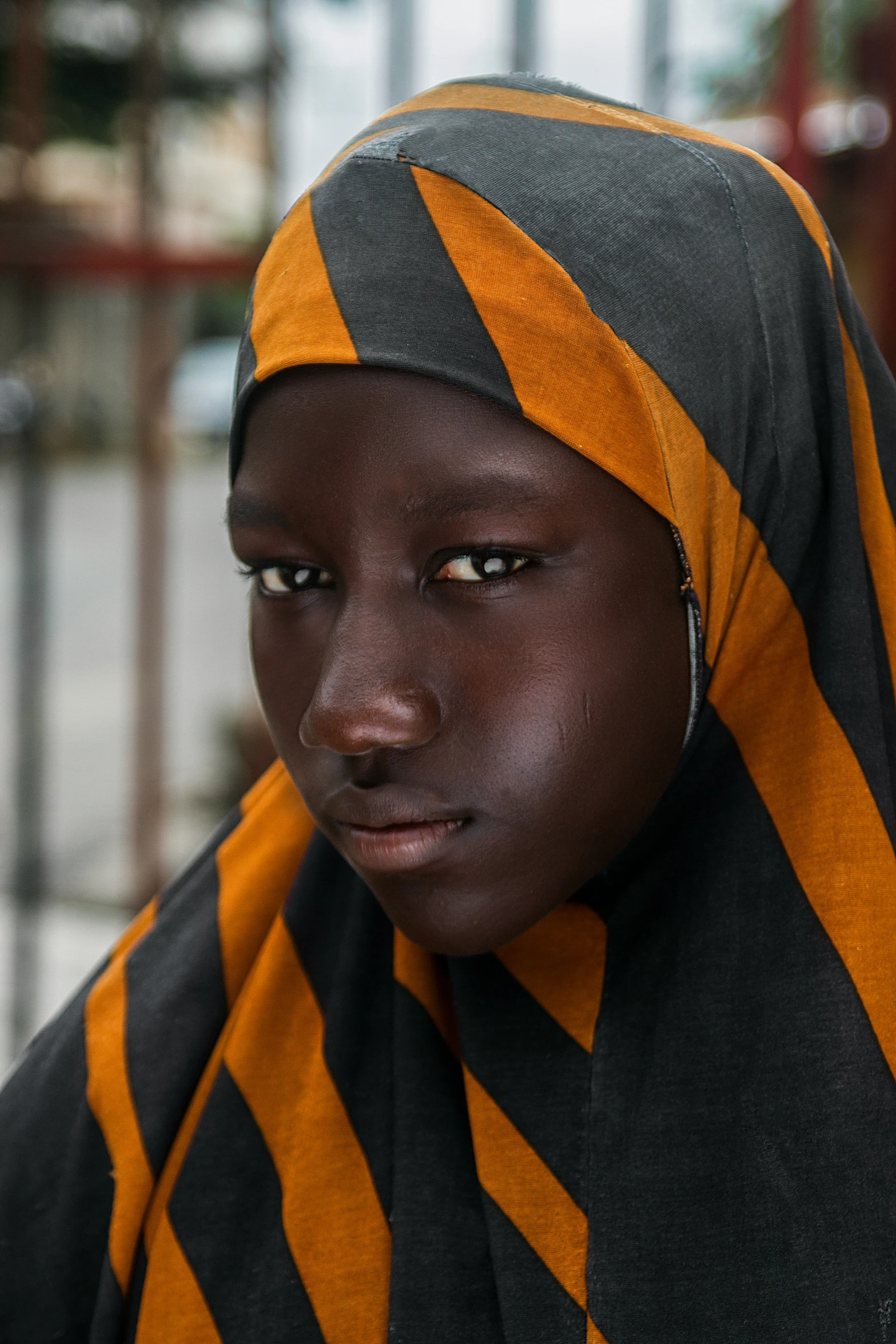 a close - up of a young woman in a black and orange outfit