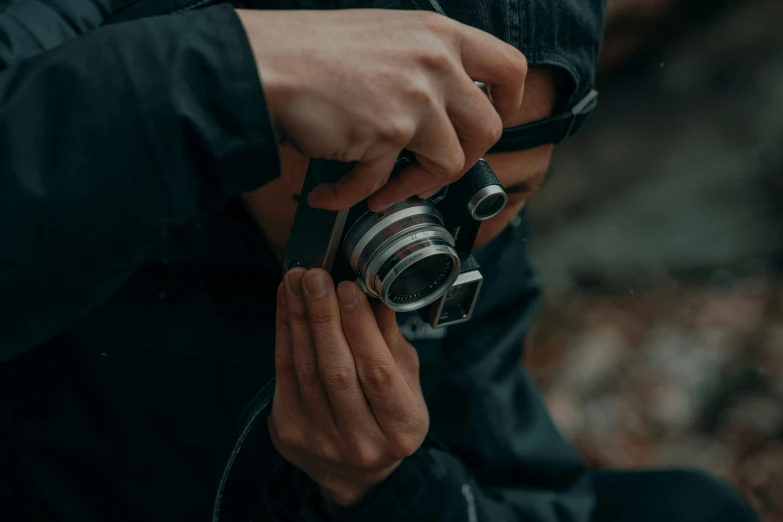 person holding camera over hand on rocky surface